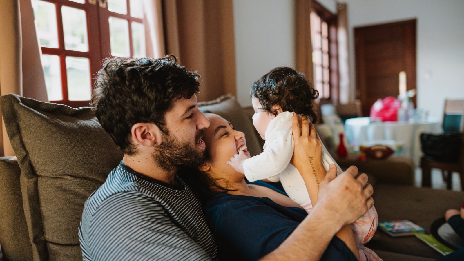 Couple sitting on couch with their baby